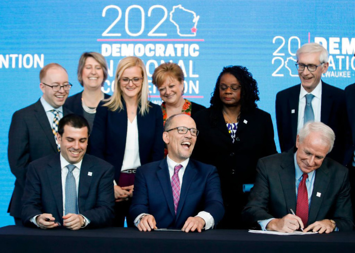 Milwaukee Mayor Tom Barrett (bottom R) signs a document announcing the selection of Milwaukee as the 2020 Democratic National Convention host city as Wisconsin Governor Tony Evers (R) and Chair of the Democratic National Committee Tom Perez (bottom C) look on during a press conference at the Fiserv Forum in Milwauee, Wisconsin, on March 11, 2019. Democrats have chosen Milwaukee as the site of their 2020 election convention, in an attempt to win back swing voters in the American 'Rust Belt' who helped elect President Donald Trump. 