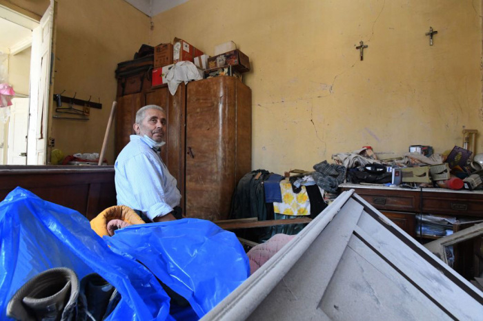 A man sits inside his damaged house in the Lebanese capital Beirut on August 6, 2020, two days after a massive explosion shook the Lebanese capital. - The blast, which appeared to have been caused by a fire igniting 2,750 tonnes of ammonium nitrate left unsecured in a warehouse, was felt as far away as Cyprus, some 150 miles (240 kilometres) to the northwest. The scale of the destruction was such that the Lebanese capital resembled the scene of an earthquake, with thousands of people left homeless and thousands more cramming into overwhelmed hospitals for treatment. 