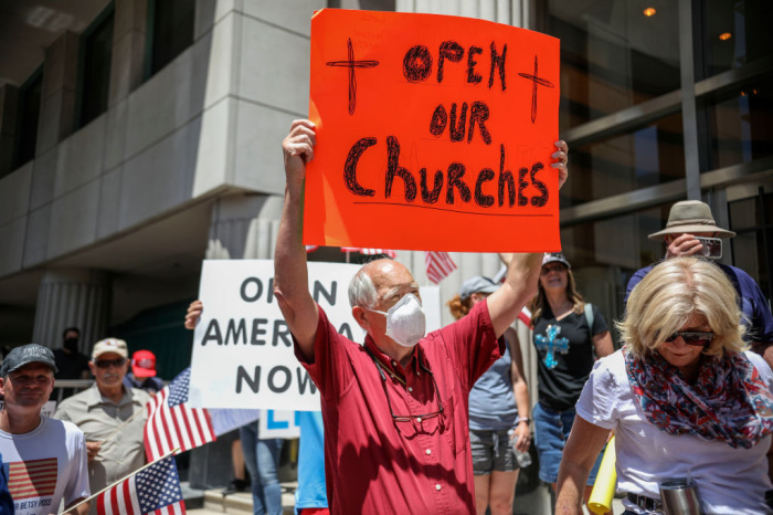 Demonstrators holding signs demanding their church to reopen, protest during a rally to re-open California and against extending Stay-At-Home directives on May 1, 2020, in San Diego, California. 