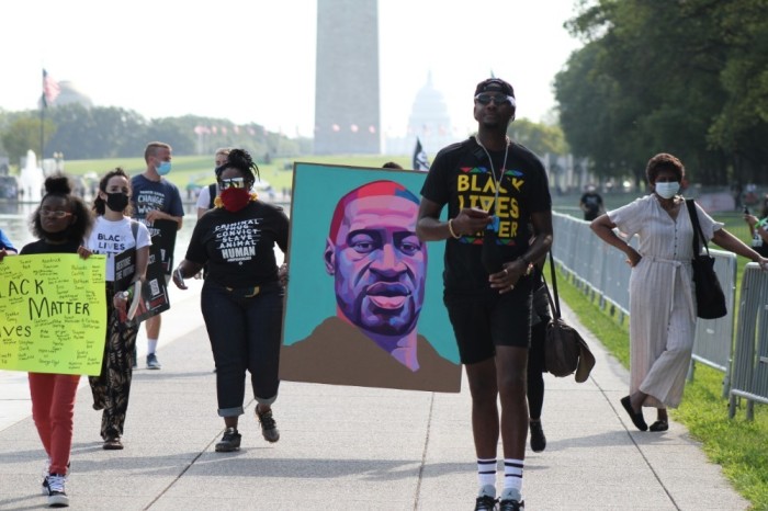 Demonstrators holding a picture of George Floyd participate in the Get Your Knee Off Our Necks Commitment March in Washington D.C. on Aug. 28. 2020. 