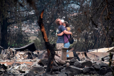 Dee Perez comforts Michael Reynolds in the ruins of his home destroyed in the Almeda Fire in Talent, Oregon, September 15, 2020. Infernos across California, Oregon and Washington state have burned more than 5 million acres (2 million hectares) this year, killed dozens of people and forced hundreds of thousands from their homes.