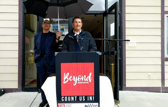Joe Wittwer, lead pastor of Life Center Church (podium) is shielded from rain by Bethel AME Church Pastor Emeritus Lonnie Mitchell on Friday September 25, 2020 in in Spokane, Wash. 