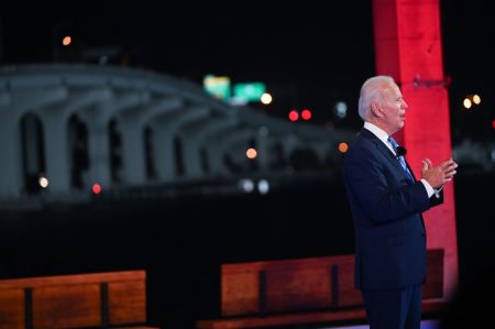Democratic presidential nominee and former Vice President Joe Biden checks his watch during an NBC Town Hall event at the Perez Art Museum, with the MacArthur Causeway in the background, in Miami, Florida on October 5, 2020.