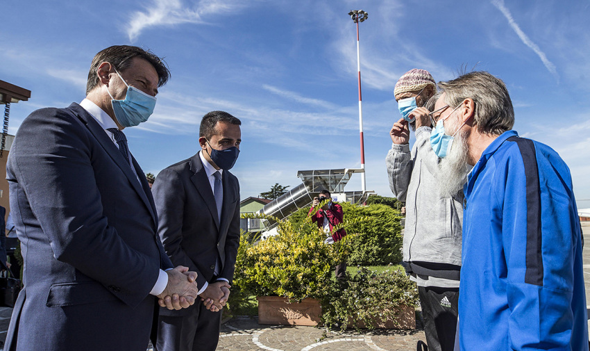 Italian Priest Pier Luigi Maccalli (R) and Italian citizen Nicola Chiacchio (2ndR) are welcomed by Italy's Prime Minister Giuseppe Conte (L) and Italy's Foreign Minister Luigi Di Maio upon their arrival at Rome's Ciampino airport on October 9, 2020. The two Italian hostages were released by insurgents in Mali on October 8, 2020, along with French aid worker Sophie Petronin and a prominent Malian politician, Soumaila Cisse. Maccalli, who was abducted in neighboring Niger in 2018, and Nicola Chiacchio, who went missing last year while on a solo bicycle trip, were also freed.