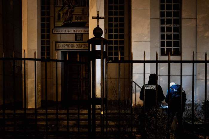 Police officers examine the entrance of the Orthodox Church where an attacker armed with a sawn-off shotgun wounded an Orthodox priest in a shooting, on October 31, 2020, in Lyon, said a police source. 