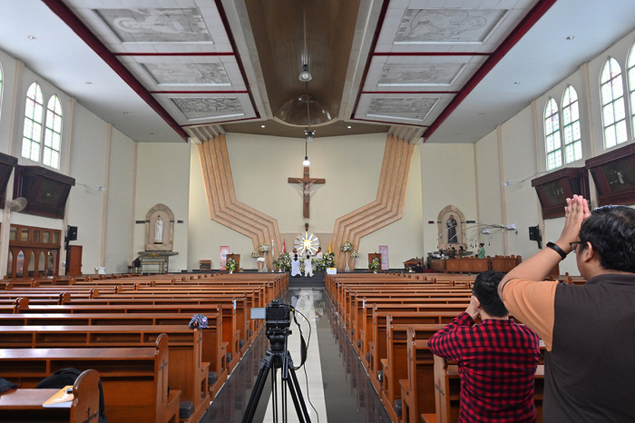 Members of the clergy conduct Easter mass in an empty church and streamed online as part of social distancing measures amidst the COVID-19 coronavirus pandemic in Jakarta on April 12, 2020. 