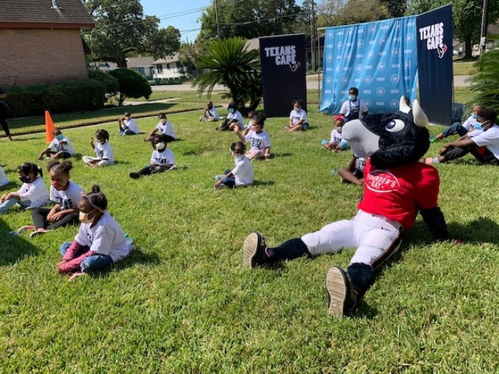 Students gather outside as members of the Houston Texans visit a Sanctuaries of Learning campus in Houston, Texas on Houston Texans' Founder's Day. The Sanctuaries of Learning were distance learning centers set up by the Texas Annual Conference of the United Methodist Church for children in Houston, Texas, 2020.