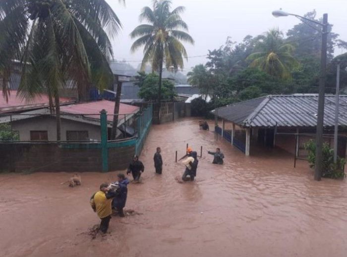 People walk around buildings flooded by the heavy rains caused by Hurricane Iota in Jinotega, north of Nicaragua, November 2020.