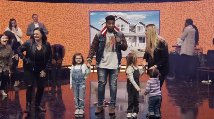A family reacts as Pastor Michael Todd of Transformation Church in Bixby, Oklahoma, announces that his church has decided to bless them with a new car and $250,000 to purchase a house on Sunday, December 13, 2020.