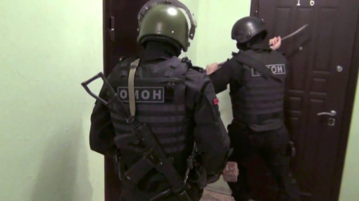 Russian police prepare to conduct a raid