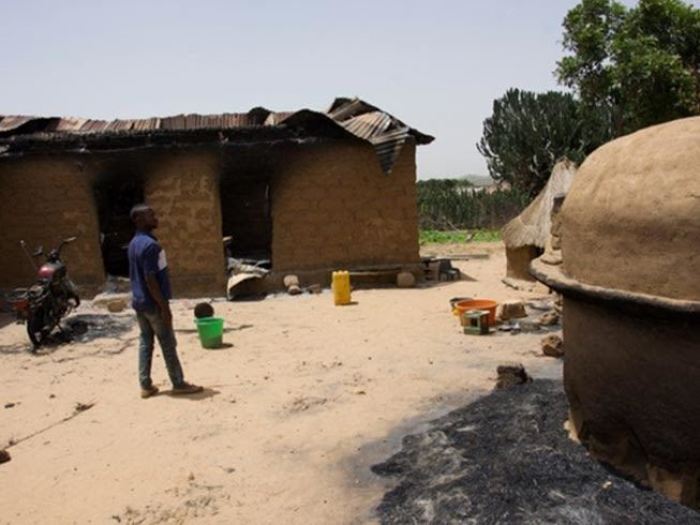 A man observes damaged property following a Fulani herdsmen attack in Nigeria.