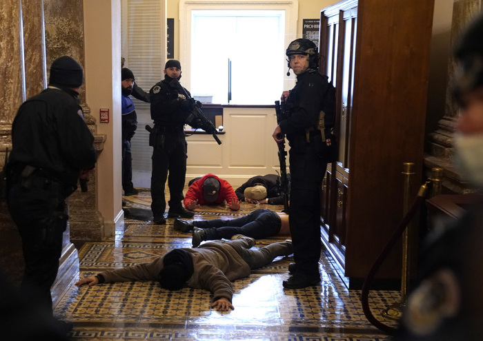 U.S. Capitol Police stand detain protesters outside of the House Chamber during a joint session of Congress on January 06, 2021, in Washington, DC. Congress held a joint session today to ratify President-elect Joe Biden's 306-232 Electoral College win over President Donald Trump. A group of Republican senators said they would reject the Electoral College votes of several states unless Congress appointed a commission to audit the election results.