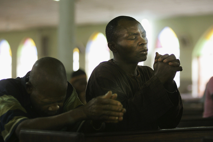 Nigerian Catholic worshiper pray during morning mass April 12, 2005, in Kano, Nigeria. Kano is part of Nigeria's primarily Muslim north, but a devoted Catholic minority participates in frequent Masses in local cathedrals. 
