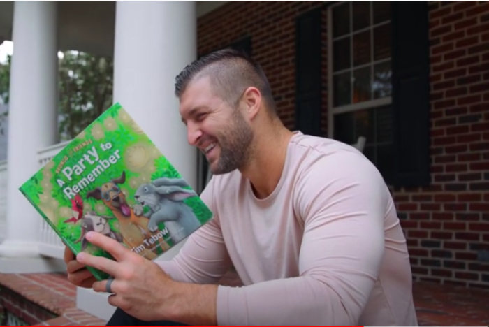 Outspoken Christian athlete Tim Tebow holds a copy of his children's book, 'Bronco and Friends: A Night to Remember.' 
