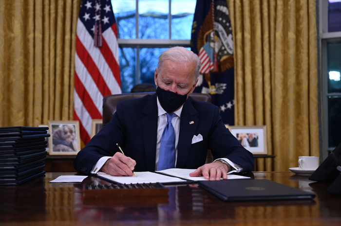 President Joe Biden sits in the Oval Office as he signs a series of executive orders at the White House in Washington, D.C., after being sworn in at the U.S. Capitol on January 20, 2021.