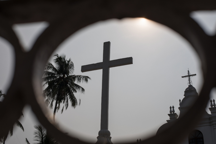 A religious cross is captured through some ornamental railings in the Fort Kochi area in the state of Kerala in South India.
