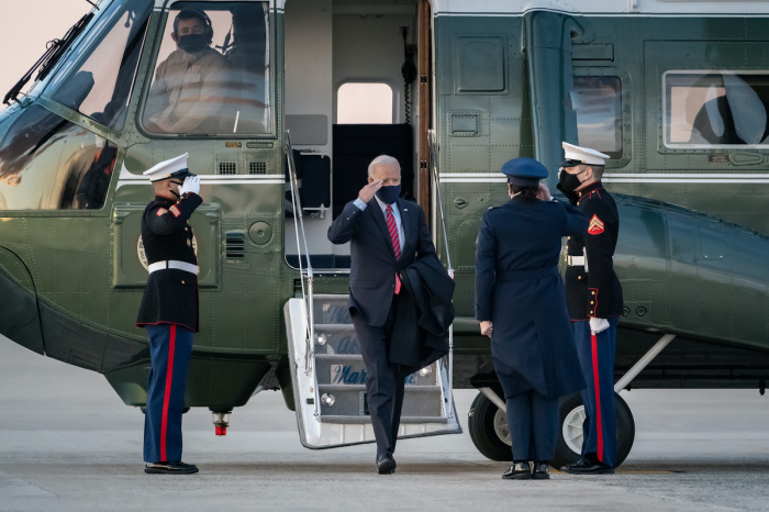 President Joe Biden salutes as he disembarks Marine One at Joint Base Andrews, Maryland Friday, Feb. 5, 2021, prior to boarding Air Force One to begin his flight to New Castle County Airport in New Castle, Delaware. 