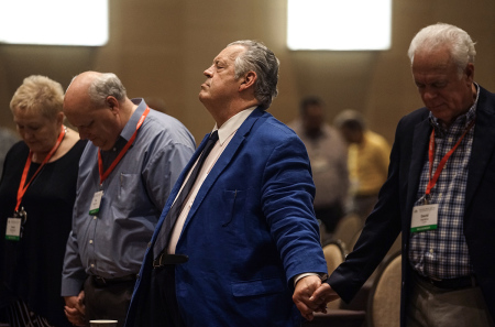 Dr. Richard Land, middle, president of Southern Evangelical Seminary in Charlotte, N.C., prays with David Hankins, right, executive director of the Louisiana Baptist Convention, and other attendees at a meeting of Connect316 June 11, 2018, at the Omni Hotel in Dallas, Texas. Connect316 is an organization advocating a "traditionalist" view of the doctrine of salvation.
