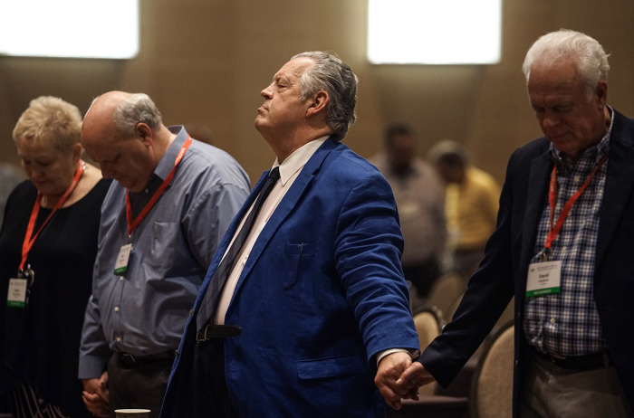 Dr. Richard Land, middle, president of Southern Evangelical Seminary in Charlotte, N.C., prays with David Hankins, right, executive director of the Louisiana Baptist Convention, and other attendees at a meeting of Connect316 June 11, 2018, at the Omni Hotel in Dallas, Texas. Connect316 is an organization advocating a 'traditionalist' view of the doctrine of salvation. 