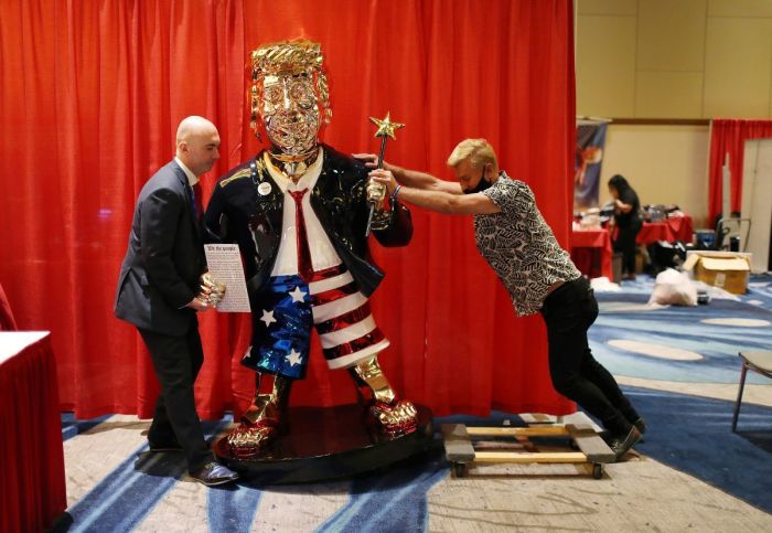 Matt Braynard (L) helps artist Tommy Zegan (R) move his statue of former President Donald Trump to a van during the Conservative Political Action Conference on February 27, 2021 in Orlando, Florida. 