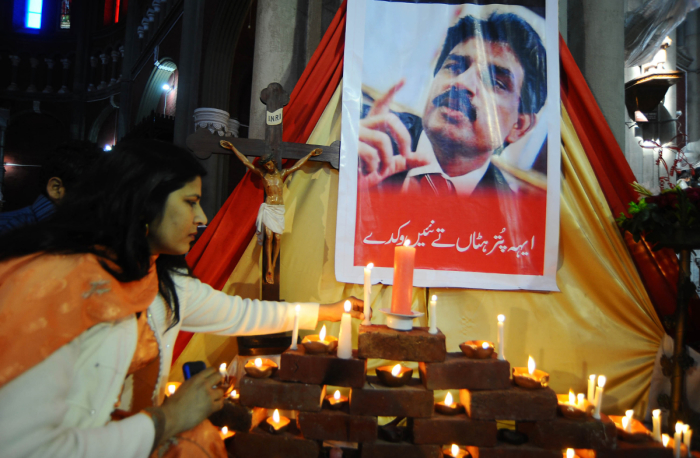 A Pakistani Christian woman lights candles in front of a picture of slain Christian minister Shahbaz Bhatti at The Heart Cathedral Church in Lahore on March 6, 2011. Bhatti, who was an outspoken campaigner against Pakistan's Islamic blasphemy laws, died in a hail of bullets on March 2, as he left his mother's home in the Pakistani capital Islamabad.