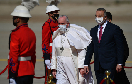 Pope Francis walks alongside Iraq's Prime Minister Mustafa al-Kadhem upon his arrival in Baghdad on March 5, 2021, on the first papal visit to Iraq. Pope Francis began his historic trip to war-scarred Iraq, defying security concerns and the coronavirus pandemic to comfort one of the world's oldest and most persecuted Christian communities.