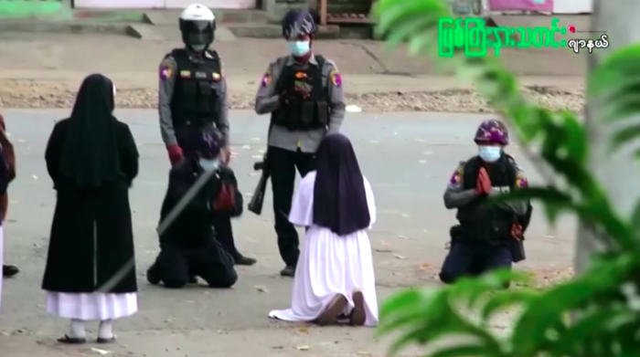 A now-viral video shows Sister Ann Rose Nu Tawng, a member of the Sisters of St. Francis Xavier congregation, in a white robe and black habit kneeling on a street in the town of Myitkyina, speaking to two policemen who were also kneeling.
