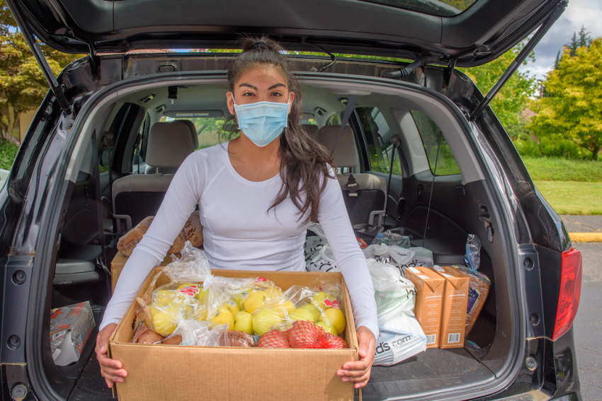 Diana Vergara holds a Fresh Food Box donated to her family by World Vision at Auburn City Adventist Church in Auburn, Washington.