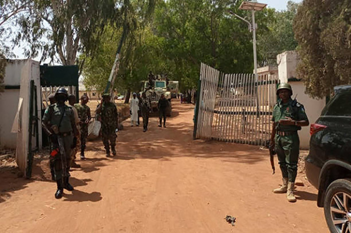 Nigerian soldiers and police officers stand at the entrance of the Federal College of Forestry Mechanisation in Mando, Kaduna state, on March 12, 2021, after gunmen stormed the school and kidnapped students. 