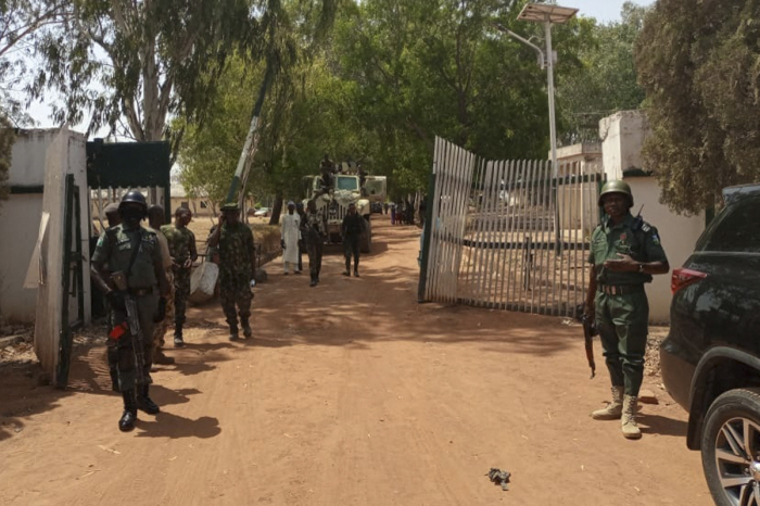 Nigerian soldiers and police officers stand at the entrance of the Federal College of Forestry Mechanisation in Mando, Kaduna state, on March 12, 2021, after a kidnap gang stormed the school shooting indiscriminately on March 11, 2021. 