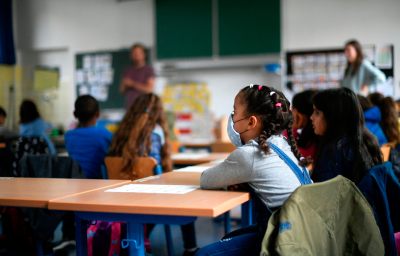 A girl wears a face mask as students sit in a classroom of the Petri primary school in Dortmund, western Germany, on June 15, 2020 amid the novel coronavirus COVID-19 pandemic.