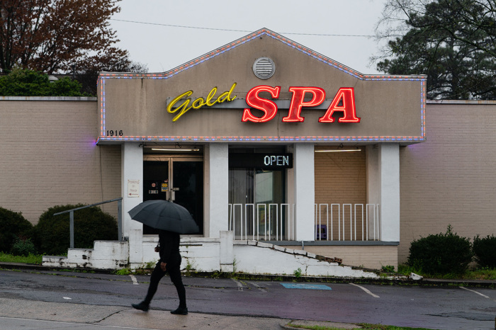 A man walks past a massage parlor where three women were shot and killed on March 17, 2021, in Atlanta, Georgia. Suspect Robert Aaron Long, 21, was arrested after a series of shootings at three Atlanta-area spas left eight people dead on Tuesday night, including six Asian women. 