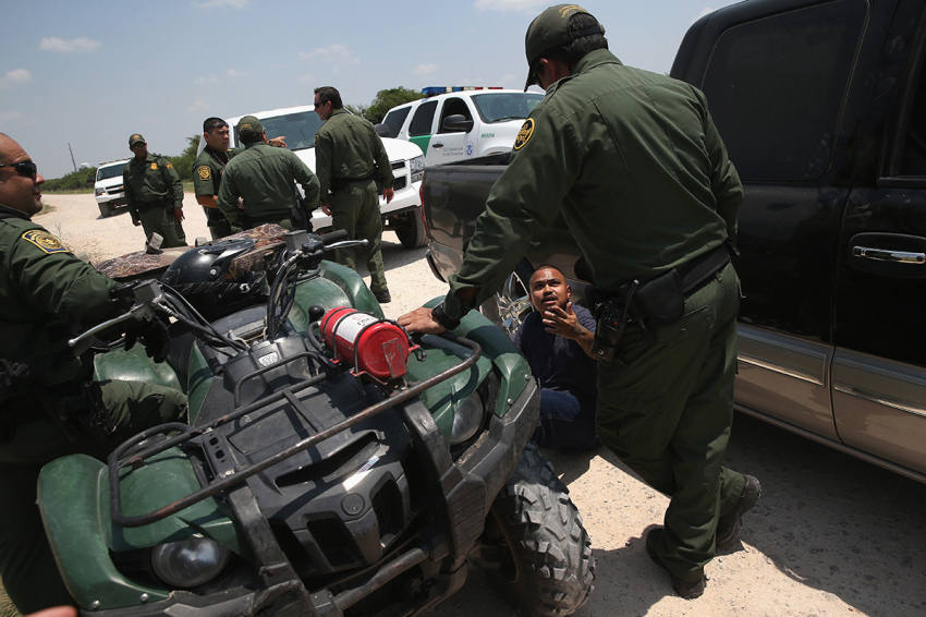 U.S. Border Patrol agents detain a suspected smuggler after he allegedly transported immigrants illegally into the United States on July 24, 2014, in Mission, Texas.