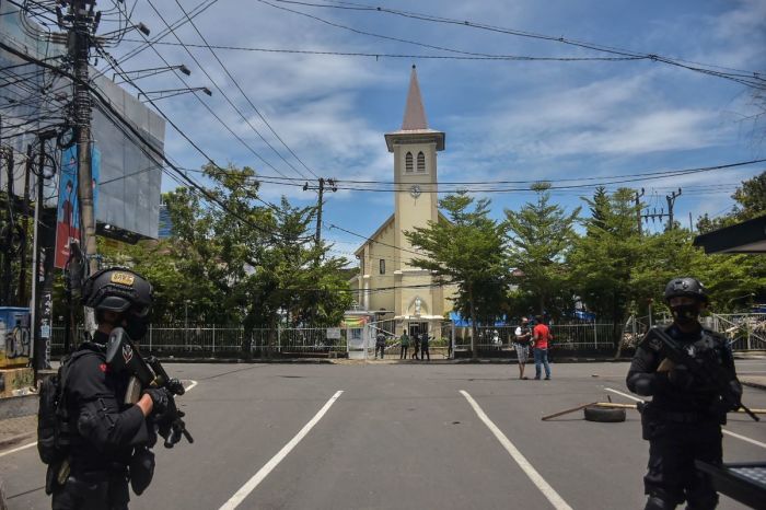 Indonesian police stand guard as they seal the area after an explosion outside a church in Makassar, Indonesia on March 28, 2021.