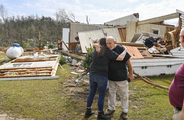 A neighbor hugs Danny Poss, pastor of Ragan Chapel United Methodist Church, as he surveys tornado damage at the church, on March 26, 2021, in Ohatchee, Alabama. 