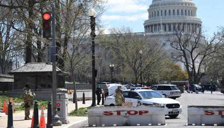 Police and members of the National Guard block a street near the U.S. Capitol on April 2, 2021, after a vehicle drove into U.S. Capitol police officers in Washington, D.C. Two police officers were injured near the U.S. Capitol on Friday after being rammed by a vehicle whose driver was subsequently arrested, police said. "A suspect is in custody. Both officers are injured. All three have been transported to the hospital," the US Capitol Police department said on Twitter. 