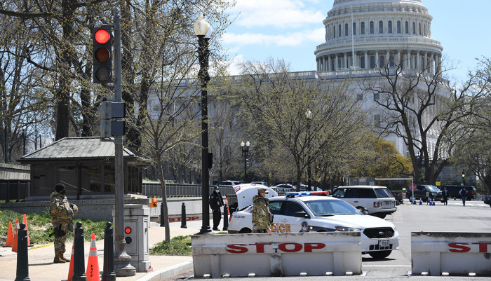 Police and members of the National Guard block a street near the U.S. Capitol on April 2, 2021, after a vehicle drove into U.S. Capitol police officers in Washington, D.C. Two police officers were injured near the U.S. Capitol on Friday after being rammed by a vehicle whose driver was subsequently arrested, police said. 'A suspect is in custody. Both officers are injured. All three have been transported to the hospital,' the US Capitol Police department said on Twitter. 