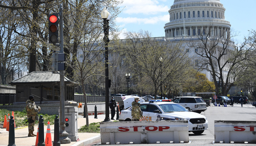 Police and members of the National Guard block a street near the U.S. Capitol on April 2, 2021, after a vehicle drove into U.S. Capitol police officers in Washington, D.C. Two police officers were injured near the U.S. Capitol on Friday after being rammed by a vehicle whose driver was subsequently arrested, police said. "A suspect is in custody. Both officers are injured. All three have been transported to the hospital," the US Capitol Police department said on Twitter. 