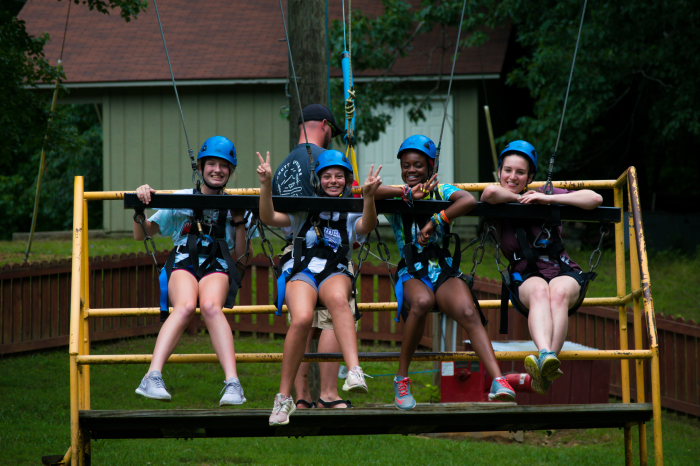 Overcoming any fear of heights, 4 girls at WinShape Camps in Crandall, GA prepare to be raised up on the big swing.