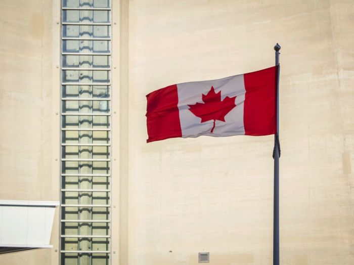 The Canadian flag flies outside the CN Tower in Toronto, Ontario, Canada. 