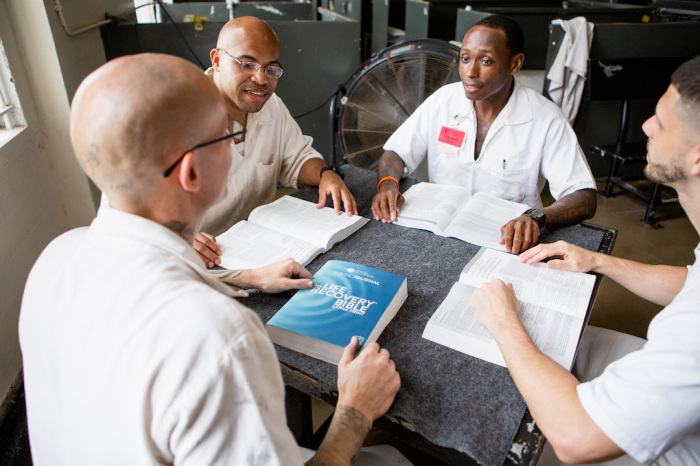 Four incarcerated men study The Life Recovery Bible distributed by Prison Fellowship during the COVID-19 pandemic. 