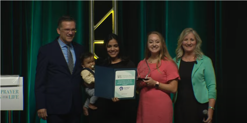Representatives of the pro-life group Students for Life accept the Pro-Life Impact Award from Heroic Media President Brett Atteberry and National Prayer Luncheon for Life Executive Director and spokesperson Karen Garnett at the 2021 National Prayer Luncheon for Life in Grapevine, Texas, April 30, 2021. From left to right: Atteberry, Lauren Castillo, SFLA's Director of Mission Advancement, Jordan Horner, SFLA's Philanthropy Officer, and Garnett.