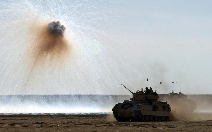A U.S. Army Bradley fighting vehicle uses a defensive smoke screen charge to help conceal its movement during a live fire trench clearing training mission on January 25, 2003, near the Iraqi border in northern Kuwait. The U.S. military is expected to have upwards of 150,000 troops in the region by mid-February ahead of any possible action in Iraq.