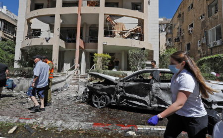 Members of Israeli security and emergency services work on a site hit by a rocket in Ramat Gan near the coastal city of Tel Aviv, on May 15, 2021, following the launching of rockets from the Gaza Strip controlled by the Palestinian Hamas movement towards Israel. - An Israeli man was killed after a rocket fired by Palestinian militants in Gaza hit the central city of Ramat Gan near Tel Aviv, police and medics said.