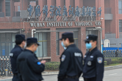 Security personnel stand guard outside the Wuhan Institute of Virology in Wuhan as members of the World Health Organization (WHO) team investigating the origins of the COVID-19 coronavirus make a visit to the institute in Wuhan in China's central Hubei province on February 3, 2021. 
