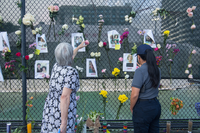 People view a makeshift memorial near the site of the residential building collapse in Miami-Dade County, Florida, the United States, on June 26, 2021. The death toll from the partial collapse of a 12-story residential building has risen to five while the number of missing people rose to at least 159, local media reported on Saturday. 