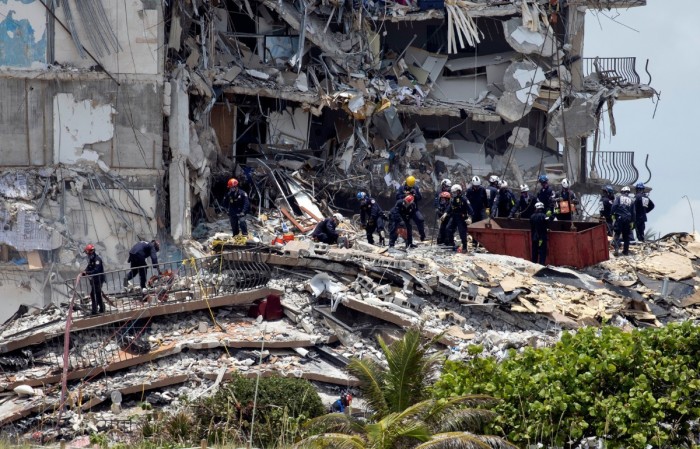Members of the South Florida Urban Search and Rescue team look for possible survivors in the partially collapsed 12-story Champlain Towers South condo building on June 26, 2021 in Surfside, Florida.