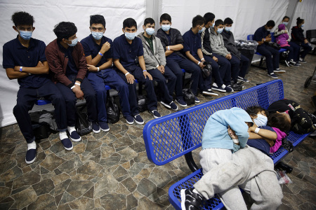 Young unaccompanied migrants wait for their turn at the secondary processing station in the Department of Homeland Security holding facility on March 30, 2021 in Donna, Texas. The Donna location is the main detention center for unaccompanied children coming across the U.S. border in the Rio Grande Valley. It is an overcrowded tent structure where more than 4,000 kids and families are kept in pods, with the youngest kept in a large playpen with mats on the floor for sleeping.