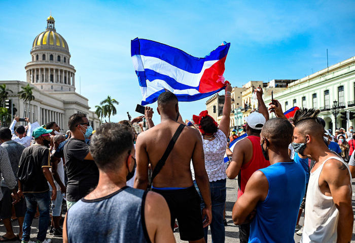 Cubans are seen outside Havana's Capitol during a demonstration against the government of Cuban President Miguel Diaz-Canel in Havana, on July 11, 2021. - Thousands of Cubans took part in rare protests Sunday against the communist government, marching through a town chanting 'Down with the dictatorship' and 'We want liberty.' 