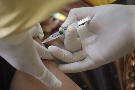 A COVID-19 vaccination injection is administered.